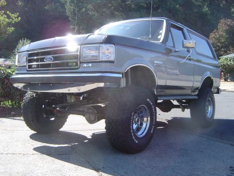 1989 Ford Bronco - This lifted 1989 Ford Bronco 4x4 features prominent off-road tires and a chrome front bumper.