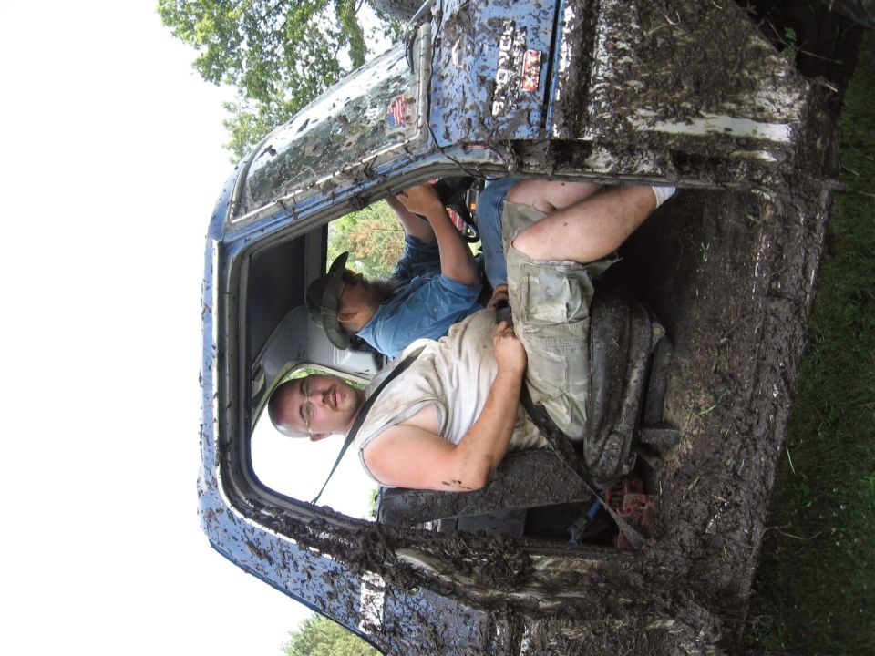 1979 Ford Bronco interior covered in mud with two men inside