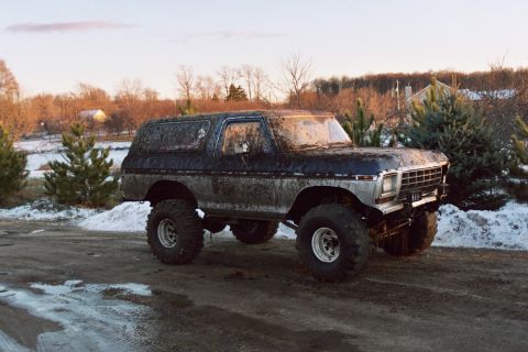 1979 Ford Bronco - This lifted 1979 Ford Bronco is covered in mud, suggesting it has seen some off-road action.