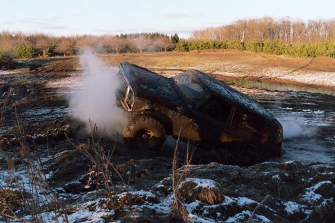1979 Ford Bronco - A 1979 Ford Bronco is stuck in the mud, with steam billowing from its engine compartment.