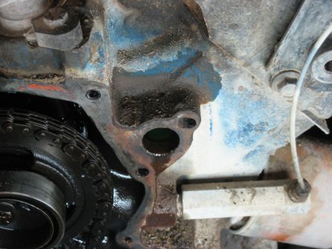 1986 Ford Bronco - Engine block detail showing timing chain and oil residue.