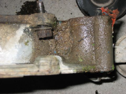 1986 Ford Bronco - This is a close-up of a dirty, corroded metal part with a bolt and some green residue.