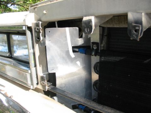 1985 Ford LTD Crown Victoria - Close-up of a car's front end, showing headlights and an installed oil cooler.