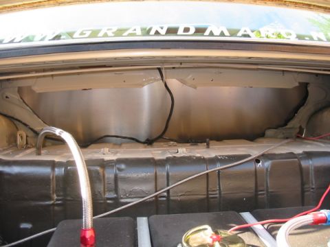 1985 Ford LTD Crown Victoria - The trunk interior shows custom metal paneling and a fuel line. Text on the rear window reads "GRANDMA.NET".