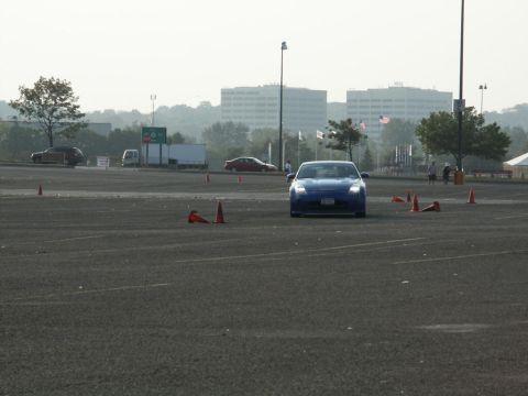 2001 Mercury Grand Marquis - A blue sports car navigates a course marked by orange cones on a hazy day.