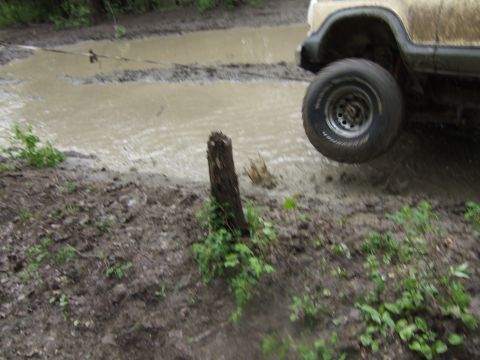 1989 Ford Bronco - Vehicle navigating a challenging muddy terrain with a single wheel off the ground.