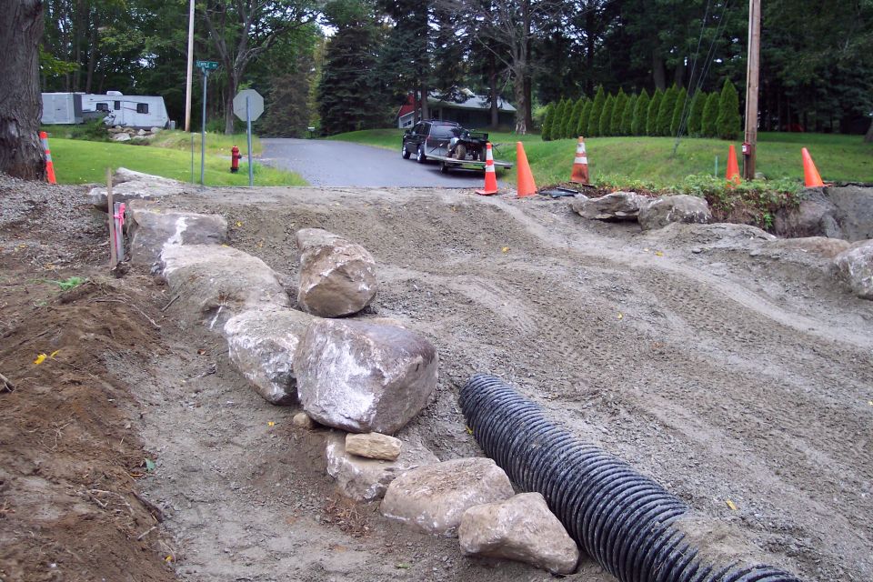 construction site with rocks, dirt, and a drainage pipe