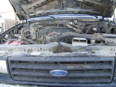 1989 Ford Bronco - The engine bay of a Ford truck is shown with the hood up, revealing the engine and various components.