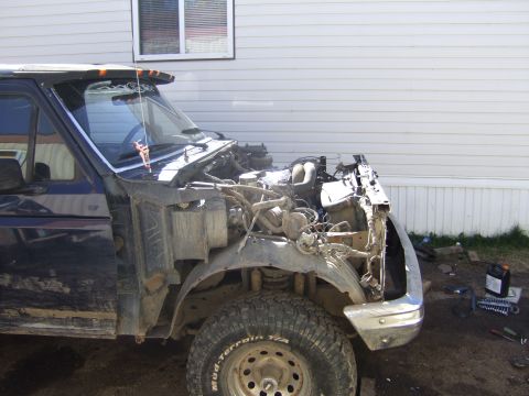 1989 Ford Bronco - This dark blue truck is missing its front end, revealing the engine and chassis components.