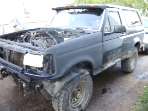 1989 Ford Bronco - This 1989 Ford Bronco is undergoing front-end work, with its hood up and engine visible.