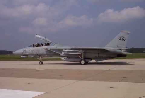 2003 Ford Crown Victoria - US Navy F-14 Tomcat fighter jet parked on tarmac, with 'NAVY' and 'VF-3' markings visible.