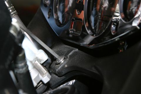 2006 Suzuki Hayabusa 1300 - Close-up of a chrome gauge bezel being worked on with an allen wrench.