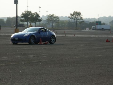 2001 Mercury Grand Marquis - A blue sports car is seen on a paved course with orange cones, possibly during a timed event.