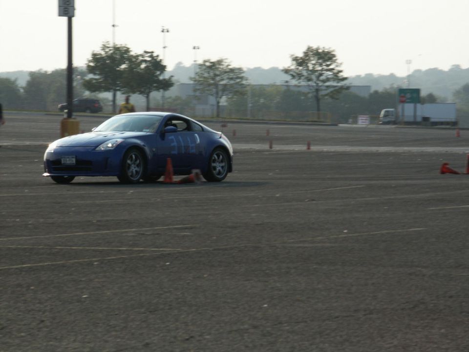 Blue sports coupe with numbers on the side, navigating a course marked by cones
