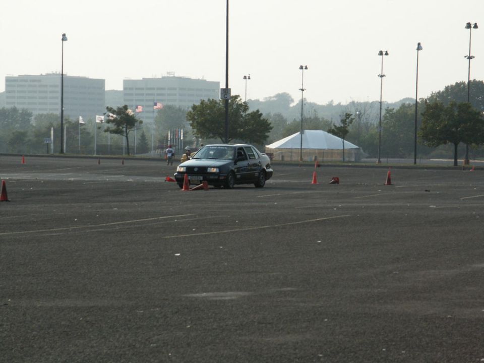 Dark sedan navigating a cone course