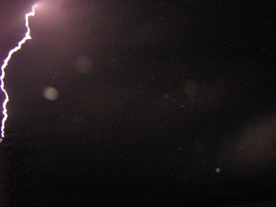 Lightning strike over dark sky with SUPERMOTORS watermark