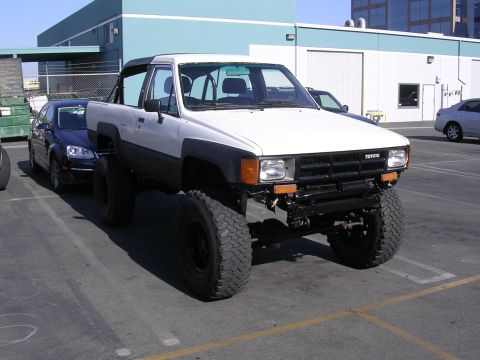 1985 Toyota 4Runner - A modified Toyota pickup truck with oversized tires sits in a parking lot.