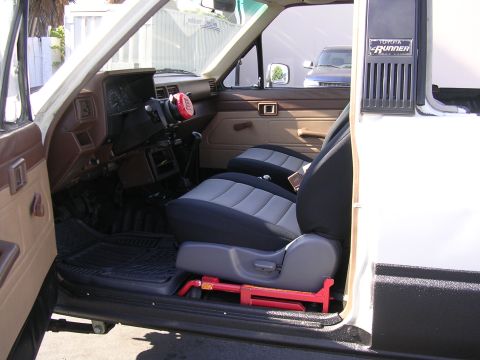 1985 Toyota 4Runner - The interior of a 1985 Toyota 4Runner features two-tone seats and a clear view of the dashboard and door panel.