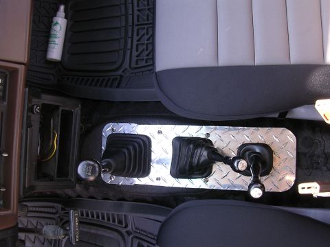 1985 Toyota 4Runner - The center console features dual shifters and a diamond plate accent, with a cleaning spray bottle nearby.