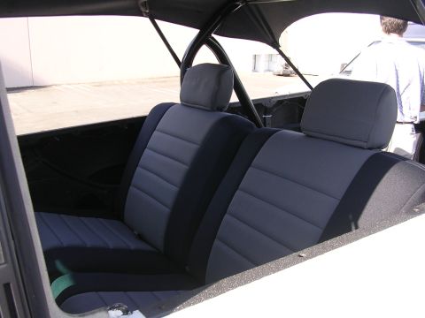 1985 Toyota 4Runner - The interior of a vehicle shows gray and black striped front seats and headrests.