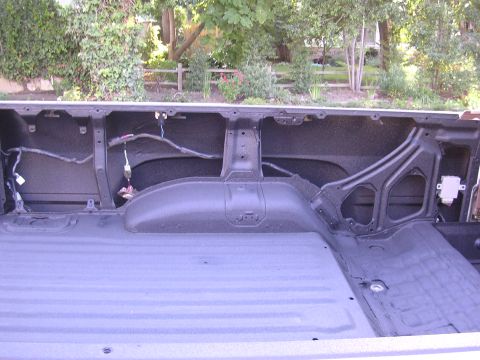 1985 Toyota 4Runner - The interior of a truck bed shows exposed wiring and the wheel well area.