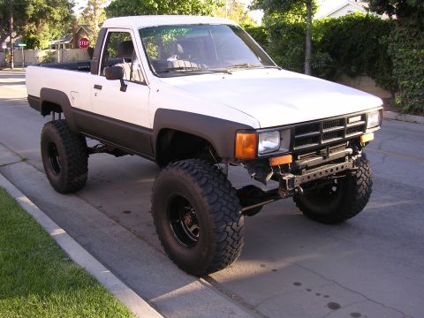 1985 Toyota 4Runner - Modified Toyota pickup truck with significant lift and oversized tires. Grille design points to a 1984 model year.
