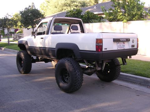 1985 Toyota 4Runner - This modified Toyota pickup truck has a lifted suspension and oversized tires, altering its original appearance.