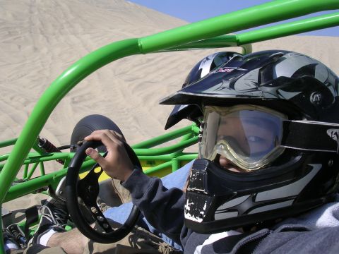 1985 Toyota 4Runner - A person drives a dune buggy through sandy terrain, with another buggy visible in the background.