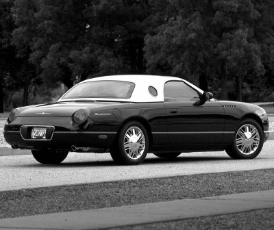 2002 Ford Thunderbird - Black 2002 Ford Thunderbird with a removable white hardtop is parked on a road.