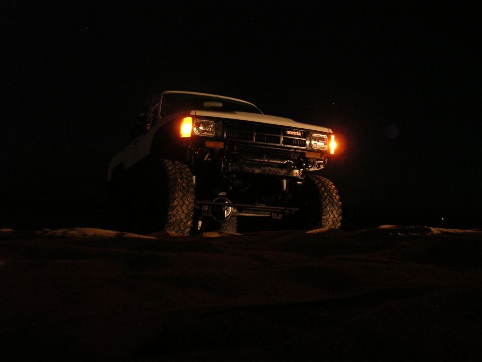 1985 Toyota 4Runner with large tires and winch, front view at night