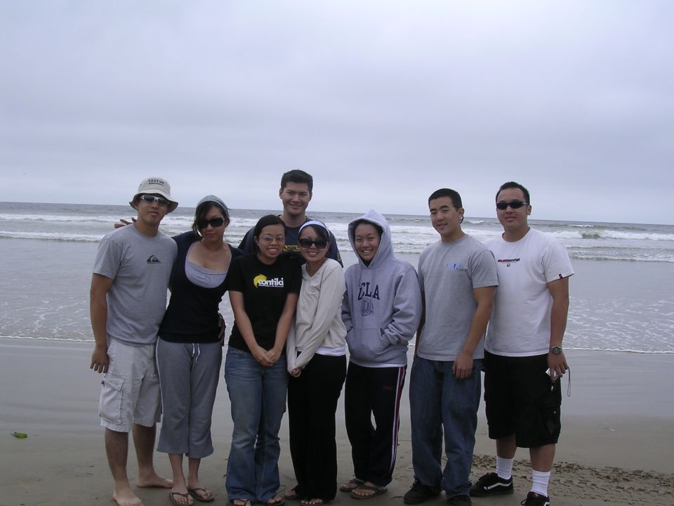 Group of people posing on a beach with the ocean in the background