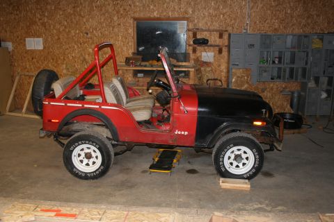 1979 Jeep CJ5 - This 1979 Jeep CJ5 is shown in a garage with a red body and black hood.