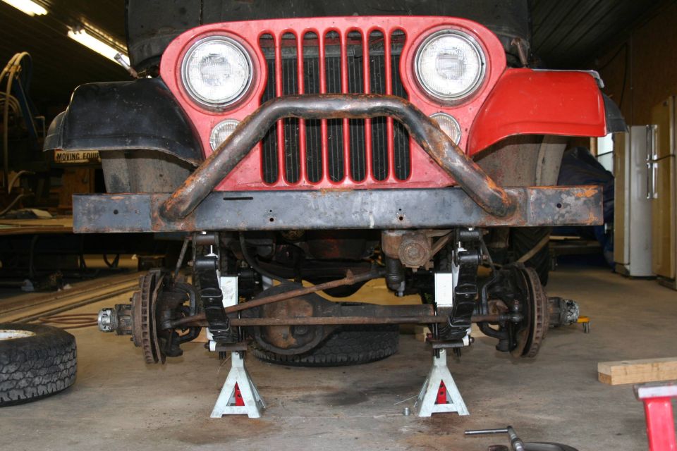 1979 Jeep CJ5 front end with custom bumper and grille, raised on jack stands for maintenance