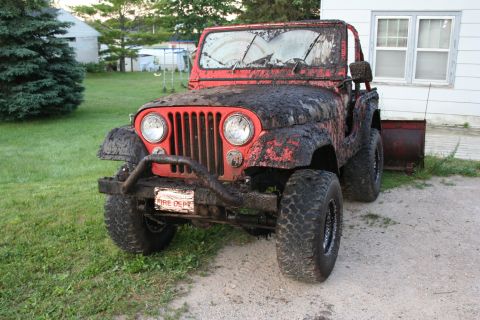 1979 Jeep CJ5 - This mud-covered 1979 Jeep CJ5 has a cracked windshield and a "FIRE DEPT" plate.
