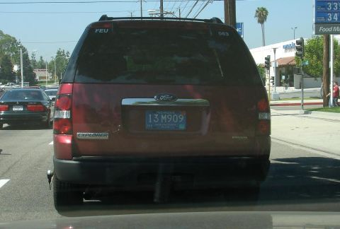 1993 Ford Taurus - A red Ford Explorer is seen from behind in traffic, with a Michigan license plate.