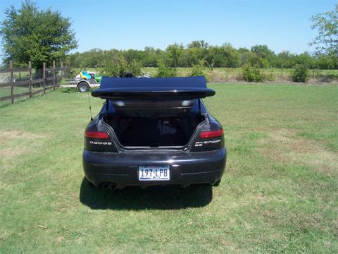 1998 Dodge Avenger - The rear of a black 1998 Dodge Avenger is shown with its trunk open, parked in a grassy field.
