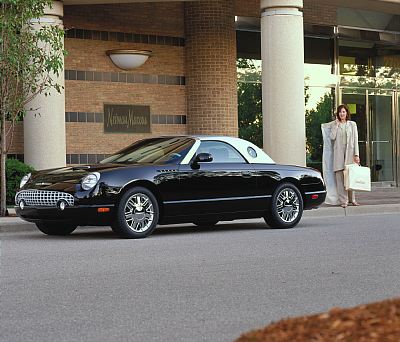 2002 Ford Thunderbird - A black 2002 Ford Thunderbird convertible with a white hardtop is parked outside a building with a Neiman Marcus sign.