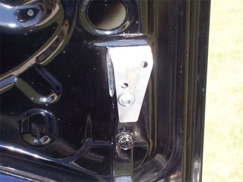 1998 Dodge Avenger - A close-up view of a modified metal bracket attached to the black interior of a car.