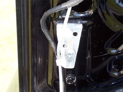 1998 Dodge Avenger - Close-up view of the trunk latch mechanism and associated wiring and hinge assembly.