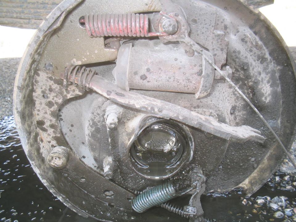 Brake drum assembly with visible wear and fluid leakage