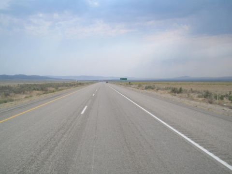 1979 Ford Bronco - Highway scene with distant mountains and a green sign in the distance.