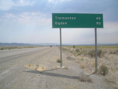 1979 Ford Bronco - A highway sign indicates distances to Tremonton and Ogden along a desolate road under a cloudy sky.
