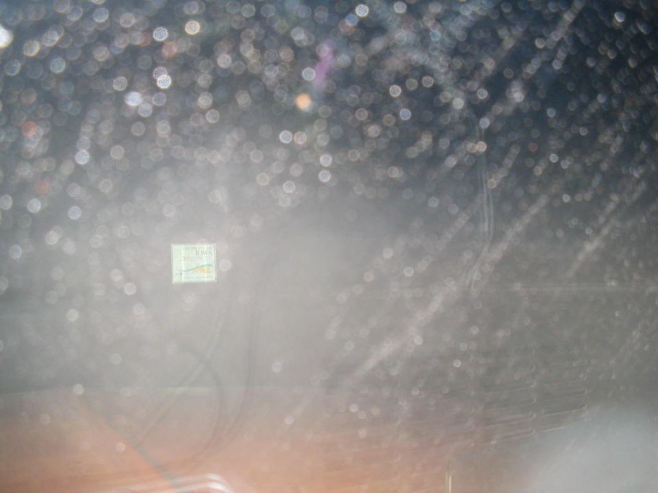 Square sticker with text and graphics on a dirty windshield