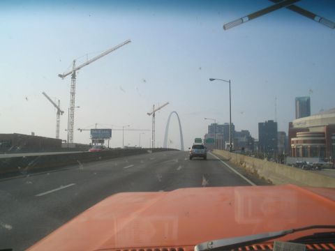 1979 Ford Bronco - View from inside an orange vehicle shows the St. Louis Arch and several construction cranes against a hazy sky.