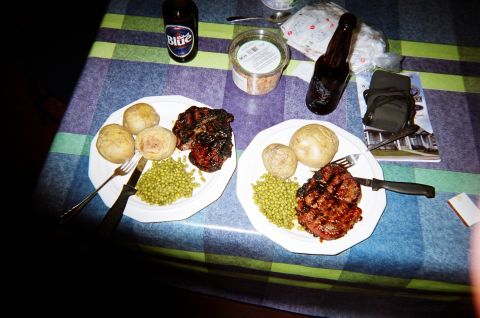 1984 Ford Bronco - A meal of steak, potatoes, and peas is served with beer on a checkered tablecloth.