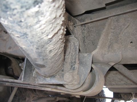 1974 Ford F-100 - Underside view of a vehicle's suspension system, showing a leaf spring and shock absorber mount.