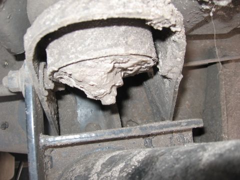 1974 Ford F-100 - Underside view of a worn suspension bushing, showing significant dirt and damage.