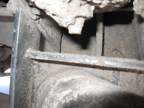 1974 Ford F-100 - Detail shot of the undercarriage, showing frame rail and suspension components covered in dust.