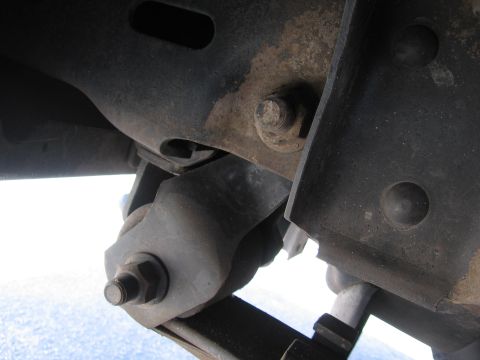 1974 Ford F-100 - Detail of a truck's suspension system, showing metal components and bolts.