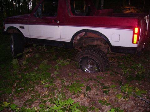2000 Chevrolet Tahoe - This off-road vehicle appears to be stuck in the mud and foliage.